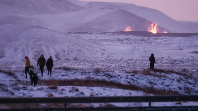 epa11037005 Onlookers gather to watch the lava flow after a volcanic eruption near the town of Grindavik, Reykjanes peninsula, Iceland, 19 December 2023. The start of a volcanic eruption was announced by Iceland's Meteorological Office on 18 December night after weeks of intense earthquake activity in the area. EPA/ANTON BRINK