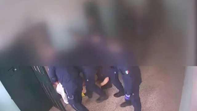 Incappucciato con un federa, messo pancia a terra con uno sgambetto e poi preso a pugni sul volto e sul costato, calpestato con gli scarponi, trattenuto alcuni minuti per braccia e gambe dagli agenti della polizia penitenziaria. Poi denudato e sollevato di peso, sempre col cappuccio in testa, fino ad essere trascinato in cella, Il pestaggio subito da un 40enne detenuto tunisino, il 3 aprile in un corridoio di un carcere italiano, l'istituto di Reggio Emilia, è documentato dai video delle telecamere interne, finiti agli atti dell'inchiesta chiusa dalla Procura reggiana a carico di 10 agenti, otto accusati di tortura, 9 Febbraio 2024. ANSA/PENITENZIARIA