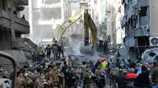 epa11735835 Armed soldiers stand guard as rescue teams, using excavators (rear), search for missing people under the rubble of a destroyed building after Israeli airstrikes hit a residential area in the Basta neighbourhood, central Beirut, Lebanon, 23 November 2024. At least 11 people were killed and 63 others injured after Israeli airstrikes hit a residential building in the Basta neighborhood in central Beirut, according to Lebanon's Ministry of Health. More than 3,640 people have been killed and more than 15,350 others injured in Lebanon since the escalation in hostilities between Israel and Hezbollah, the ministry said. EPA/ABBAS SALMAN