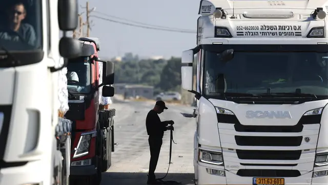 epaselect epa11714196 A driver inspects the cargo at the border gate as World Food Programme (WFP) aid trucks pass through the Erez crossing on the border with northern Gaza Strip, in southern Israel, 11 November 2024. According to the Israeli Army (Tsahal) and Coordination of Government Activities in the Territories (COGAT), 40 World Food Programme (WFP) aid trucks crossed into the northern Gaza Strip from Israel. According to the United Nations over 1.8 million people in Gaza face extreme hunger. EPA/VASSIL DONEV