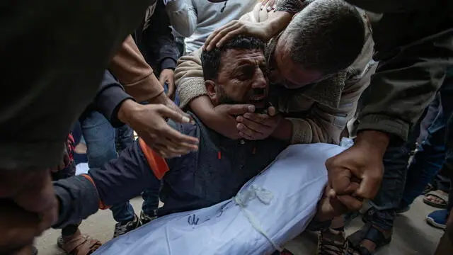 epa11735783 A father mourns as he carries the body of his son, who was killed in an Israeli airstrike, at Nasser Hospital in Khan Yunis, southern Gaza Strip, 23 November 2024. At least six people, including children, were killed and several others injured in Israeli airstrikes overnight, according to medics at Nasser Hospital. More than 44,000 Palestinians and over 1,400 Israelis have been killed, according to the Palestinian Health Ministry and the Israeli Army, since Hamas militants launched an attack against Israel from the Gaza Strip on 07 October 2023, and the Israeli operations in Gaza and the West Bank which followed it. EPA/HAITHAM IMAD