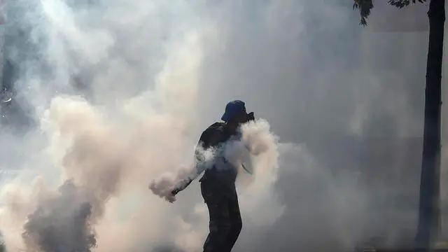 epa11136783 A retired member of the Lebanese security returns a tear gas canister towards riot police during a protest outside of the government palace in downtown Beirut, Lebanon, 08 February 2024. Retired members of the Lebanese security are demanding increased pensions after the Lebanese lira has lost more than 90 percent of its value against the dollar since the start of the economic crisis in 2019. Over the past two years, retired members of the Lebanese security have staged many nationwide protests to call for higher pensions. Veterans and security personnel have clashed, and protesters have occasionally attempted to storm into Parliament and the Banque du Liban headquarters. EPA/WAEL HAMZEH