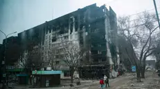 epaselect epa09887016 A picture taken during a visit to Mariupol organized by the Russian military shows local people cary water near devesteted and burned apartment building in downtown Mariupol, Ukraine, 12 April 2022. For more than a month, hostilities have continued in the city. There is no water, electricity, gas or communications. Shops, pharmacies and hospitals are closed. 250 thousand inhabitants left the city, about 300 thousand still remain. During the hostilities, up to 70 percent of the housing stock of Mariupol was destroyed and five thousand residents of the city was killed said the new mayor of the city Konstantin Ivashchenko. On 24 February Russian troops had entered Ukrainian territory in what the Russian president declared a 'special military operation', resulting in fighting and destruction in the country, a huge flow of refugees, and multiple sanctions against Russia. EPA/SERGEI ILNITSKY