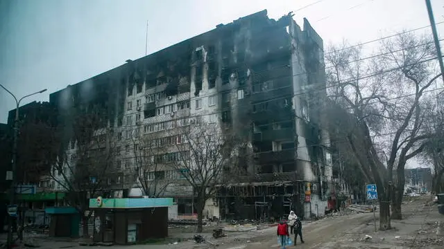 epaselect epa09887016 A picture taken during a visit to Mariupol organized by the Russian military shows local people cary water near devesteted and burned apartment building in downtown Mariupol, Ukraine, 12 April 2022. For more than a month, hostilities have continued in the city. There is no water, electricity, gas or communications. Shops, pharmacies and hospitals are closed. 250 thousand inhabitants left the city, about 300 thousand still remain. During the hostilities, up to 70 percent of the housing stock of Mariupol was destroyed and five thousand residents of the city was killed said the new mayor of the city Konstantin Ivashchenko. On 24 February Russian troops had entered Ukrainian territory in what the Russian president declared a 'special military operation', resulting in fighting and destruction in the country, a huge flow of refugees, and multiple sanctions against Russia. EPA/SERGEI ILNITSKY