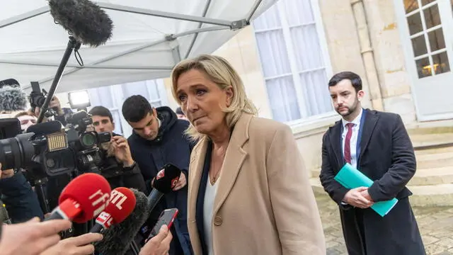 epa11739383 French member of parliament and leader of the Rassemblement National far-right party Marine Le Pen (C), flanked by party member Jean-Philippe Tanguy (R), speaks to the media after a meeting with French Prime Minister Michel Barnier (not pictured) at Matignon in Paris, France, 25 November 2024. The French Prime Minister is holding meetings with parliament group leaders. EPA/CHRISTOPHE PETIT TESSON