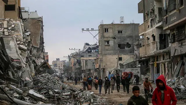 epa11747727 Palestinians walk along a street near the rubble of damaged buildings of Al Nuseirat refugee camp following an Israeli military operation at the camp, central Gaza Strip, 29 November 2024. According to the Palestinian Ministry of Health in Gaza, at least 30 Palestinians were killed and 127 others injured following an Israeli military operation in the north of Al Nuseirat refugee camp. More than 44,200 Palestinians and over 1,400 Israelis have been killed, according to the Palestinian Health Ministry and the Israeli Army, since Hamas militants launched an attack against Israel from the Gaza Strip on 07 October 2023, and the Israeli operations in Gaza and the West Bank which followed it. EPA/MOHAMMED SABER
