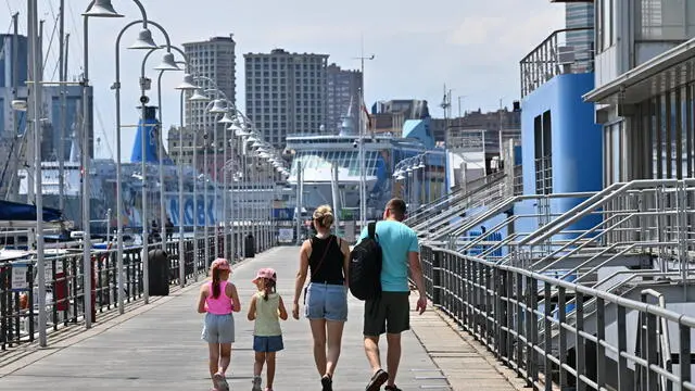 Turisti in giro per la citta' nonostante il grande caldo di questi giorni. Alcuni cercano refrigerio nelle fontane di piazza De Ferrari. Genova, 17 luglio 2024. ANSA/LUCA ZENNARO