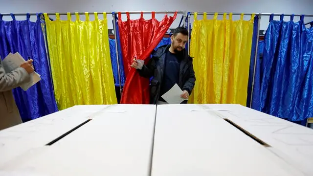 epaselect epa11751717 A Romanian man exits the voting booth after stamping his ballot during the parliamentary elections at Cezar Bolliac Primary School polling station in Bucharest, Romania, 01 December 2024. Approximately 18 million Romanian citizens are expected at the polling stations this weekend for choosing the bicameral parliament members, according to the Permanent Electoral Authority (AEP), of which 989,230 people can express their intention abroad. EPA/ROBERT GHEMENT