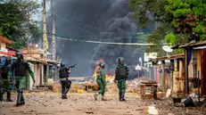 epa08758111 Guinea police fire tear gas to disperse a crowd behind burning barricades following celebrations by opposition supporters of presidential candidate Cellou Dalein Diallo in Conakry, Guinea 19 October 2020. Cellou Dalein Diallo self declared victory a day after elections. Official results are yet to be confirmed. 82 year old incumbent president Alpha Conde is seeking a controversial third term in the Guinea presidential elections. Critics claim his candidacy for a third term is illegal as the constitution provides for a maximum of two five year mandates. EPA/PAPA SECK