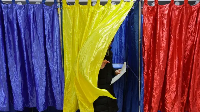 epaselect epa11751722 A Romanian woman exits the voting booth after stamping her ballot during the parliamentary elections at Cezar Bolliac Primary School polling station in Bucharest, Romania, 01 December 2024. Approximately 18 million Romanian citizens are expected at the polling stations this weekend for choosing the bicameral parliament members, according to the Permanent Electoral Authority (AEP), of which 989,230 people can express their intention abroad. EPA/ROBERT GHEMENT