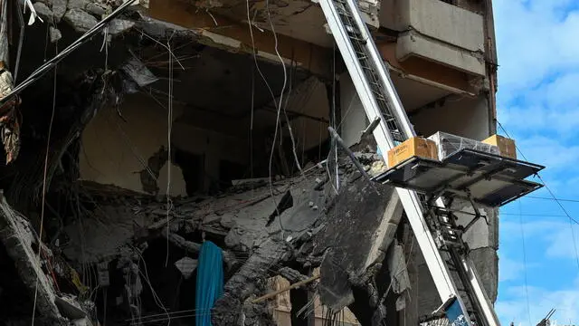 epa11747668 Workers move furniture from a damaged building as displaced residents return following a ceasefire deal in Dahieh, southern Beirut, Lebanon, 29 November 2024. A 60-day ceasefire agreement between Israel and Hezbollah came into force on 27 November. EPA/WAEL HAMZEH