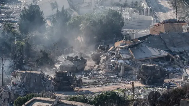 epa11753178 Israeli troops move between destroyed houses, in the south Lebanon village of Meiss El-Jabal, as they leave Lebanon on their way back into Israel, as seen from the Israeli side of the border, 02 December 2024. A 60-day ceasefire agreement between Israel and Hezbollah came into force on 27 November. EPA/ATEF SAFADI