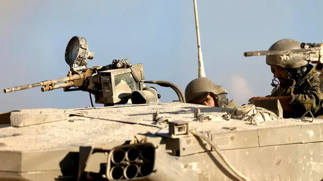 epa11714281 Israeli soldiers stand guard atop a tank while patrolling the border gate during the passing of a World Food Programme (WFP) aid convoy (not pictured) through the Erez crossing, on the border with the northern Gaza Strip, in southern Israel, 11 November 2024. According to the Israeli Army (Tsahal) and Coordination of Government Activities in the Territories (COGAT), 40 World Food Programme (WFP) aid trucks crossed into the northern Gaza Strip from Israel. According to the United Nations over 1.8 million people in Gaza face extreme hunger. EPA/VASSIL DONEV