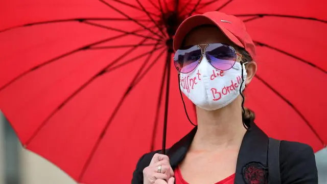 epa08628786 A sex worker with a face mask reading 'opens the brothels' as members of sex workers' organizations participate in a protest to demand an end to the prohibition to work due to the coronavirus crisis, at the State Parliament in Duesseldorf, Germany, 27 August 2020. Despite coronavirus restrictions easing for other industries, brothels remain closed throughout Germany. While neighbouring countries such as Switzerland, Belgium, Austria, the Czech Republic and the Netherlands have already generally allowed sex work again, local politics offers no prospects for the reopening of brothels and thus deprives the majority of prostitutes of their jobs. EPA/FRIEDEMANN VOGEL
