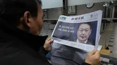 epaselect epa11755820 A man looks at a newspaper reporting South Korean President Yoon Suk Yeol announced his intention to lift the emergency martial law in Seoul, South Korea, 04 December 2024. President Yoon annnounced his intention to lift the emergency martial law hours after the National Assembly unanimously voted in favor of a resolution urging the president to withdraw the martial law during an emergency plenary session. Yoon had declared martial law the previous night, citing the need to root out pro-North Korean forces and uphold the constitutional order. EPA/HAN MYUNG-GU