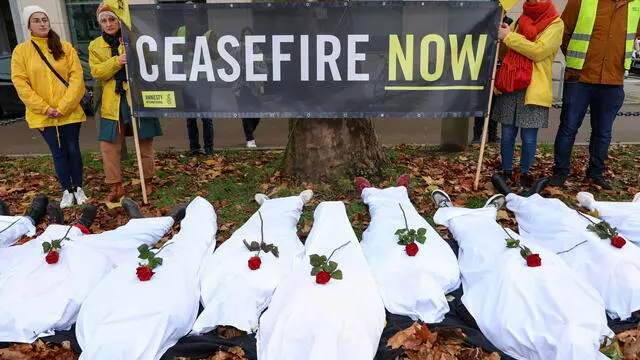 epa10980281 Human rights activists of Amnesty International display a banner and lie down covered in white sheets as they stage a demonstration calling for a ceasefire in Gaza in front of the American Embassy in Brussels, Belgium, 17 November 2023. Thousands of Israelis and Palestinians have died since the militant group Hamas launched an unprecedented attack on Israel from the Gaza Strip on 07 October, and the Israeli strikes on the Palestinian enclave which followed it. EPA/OLIVIER HOSLET
