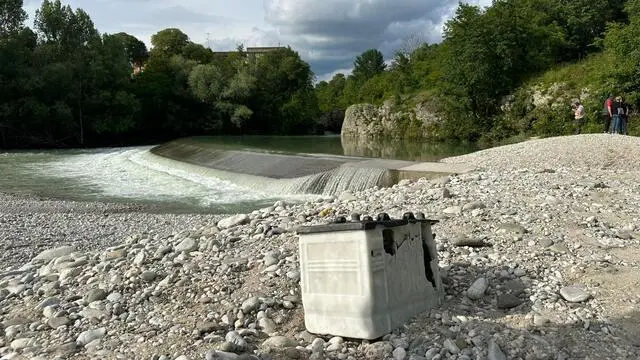 Il greto del fiume Natisone con un oggetto che indica il punto in cui tre ragazzi si sono abbracciati prima di essere travolti dalla piena