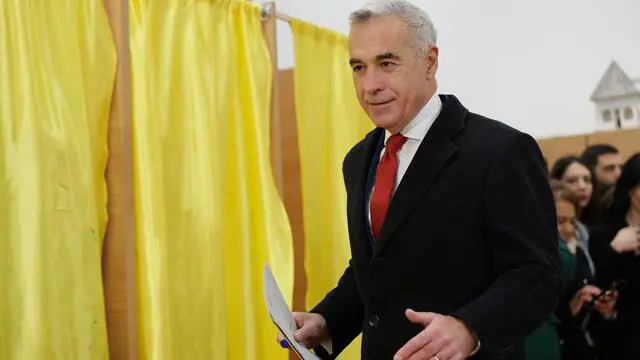 epa11750810 Romanian far-right independent runoff candidate Calin Georgescu casts his ballot for the parliamentary elections at a polling station in Secondary School No. 1 in Mogosoaia village, near Bucharest, Romania, 01 December 2024. Approximately 18 million Romanian citizens are expected at the polling stations this weekend for choosing the bicameral parliament members, according to the Permanent Electoral Authority (AEP), of which 989,230 people can express their intention abroad. Calin Georgescu led in the first round of the presidential race, winning 22.94 percent of the total number of votes, followed by Elena Lasconi, leader of the USR (Save Romania Union), with 19.18 percent. The second round of Romania's presidential election will be held on 08 December 2024. EPA/ROBERT GHEMENT