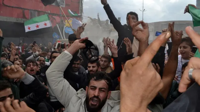 epa11764583 People shout slogans and carry Syrian flags of the opposition as they celebrate the rebel take over of Damascus, in Tripoli, northern Lebanon, 08 December 2024. Syrian rebels entered Damascus on 08 December 2024 and announced in a televised statement the 'Liberation of the city of Damascus and the overthrow of Bashar al-Assad,' as well as the release of all the prisoners. The rebels also urged the Syrian armed forces to leave Syrian public institutions, which will stay under the control of the outgoing Syrian prime minister until the official handover ceremony. EPA/STR