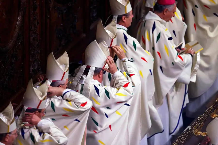 Members of the clery take part in prayers lead by the Archbishop of Paris Laurent Ulrich for the consecration of the new main altar, designed by French artist and designer Guillaume Bardet which replaces the old one that was destroyed in 2019, during a mass at the Notre-Dame de Paris cathedral, in Paris on December 8, 2024. Newly restored Notre Dame cathedral is set to hold its first service for the public on December 8, 2024 after a historic re-opening ceremony that saw firefighters, builders and artists celebrated for their work saving the 12th-century masterpiece. The beloved Paris monument nearly burned down in 2019, but has been renovated inside and fitted with a new roof and spire during a frenzied reconstruction effort since then. (Photo by Ludovic MARIN / AFP) / RESTRICTED TO EDITORIAL USE - MANDATORY MENTION OF THE ARTIST UPON PUBLICATION - TO ILLUSTRATE THE EVENT AS SPECIFIED IN THE CAPTION