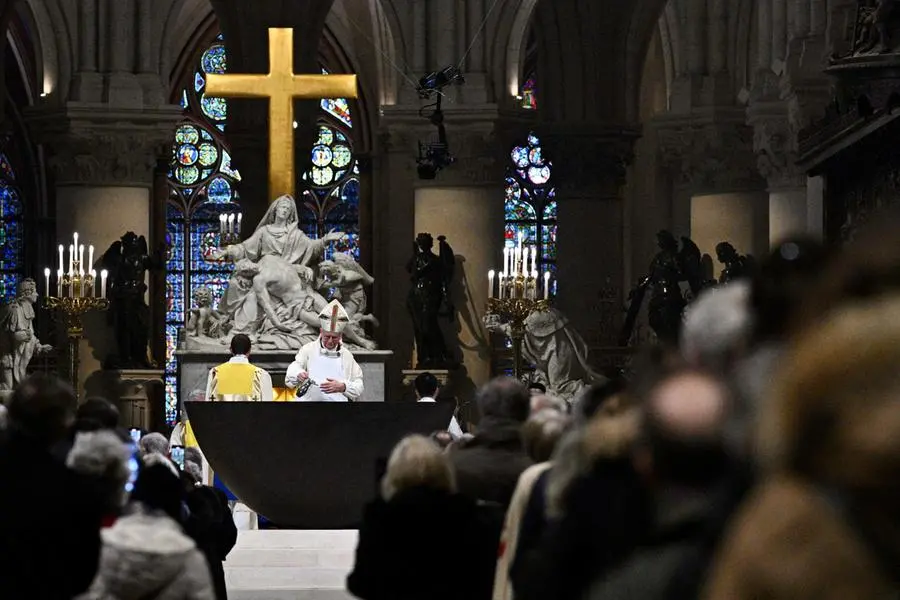 Archbishop of Paris Laurent Ulrich performs a ritual for the consecration of the main altar, designed by French artist and designer Guillaume Bardet which replaces the old one that was destroyed in 2019, during a mass at the Notre-Dame de Paris cathedral, in Paris on December 8, 2024. Newly restored Notre Dame cathedral is set to hold its first service for the public on December 8, 2024 after a historic re-opening ceremony that saw firefighters, builders and artists celebrated for their work saving the 12th-century masterpiece. The beloved Paris monument nearly burned down in 2019, but has been renovated inside and fitted with a new roof and spire during a frenzied reconstruction effort since then. (Photo by JULIEN DE ROSA / AFP) / RESTRICTED TO EDITORIAL USE - MANDATORY MENTION OF THE ARTIST UPON PUBLICATION - TO ILLUSTRATE THE EVENT AS SPECIFIED IN THE CAPTION