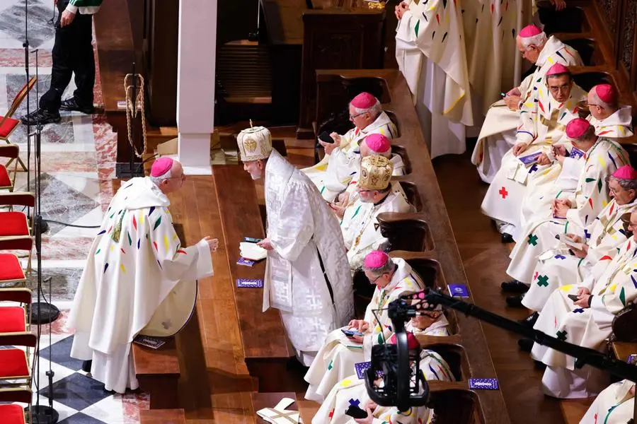 Members of the clergy wait ahead of the start of the first mass for the public in which Archbishop of Paris will lead prayers to consecrate the new main altar, at the Notre-Dame de Paris cathedral, in Paris, on December 8, 2024. Newly restored Notre Dame cathedral is set to hold its first service for the public on December 8, 2024 after a historic re-opening ceremony that saw firefighters, builders and artists celebrated for their work saving the 12th-century masterpiece. The beloved Paris monument nearly burned down in 2019, but has been renovated inside and fitted with a new roof and spire during a frenzied reconstruction effort since then. (Photo by Ludovic MARIN / AFP)