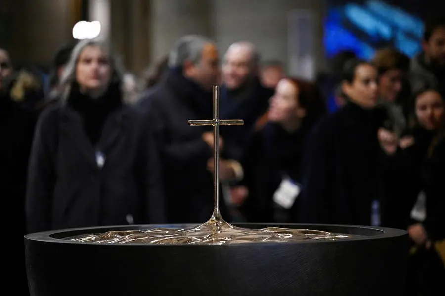 Devotees wait before the start of a mass lead by Archbishop of Paris Laurent Ulrich for the consecration of the new main altar, designed by French artist and designer Guillaume Bardet which replaces the old one that was destroyed in 2019, at the Notre-Dame de Paris cathedral, in Paris on December 8, 2024. Newly restored Notre Dame cathedral is set to hold its first service for the public on December 8, 2024 after a historic re-opening ceremony that saw firefighters, builders and artists celebrated for their work saving the 12th-century masterpiece. The beloved Paris monument nearly burned down in 2019, but has been renovated inside and fitted with a new roof and spire during a frenzied reconstruction effort since then. (Photo by JULIEN DE ROSA / AFP) / RESTRICTED TO EDITORIAL USE - MANDATORY MENTION OF THE ARTIST UPON PUBLICATION - TO ILLUSTRATE THE EVENT AS SPECIFIED IN THE CAPTION