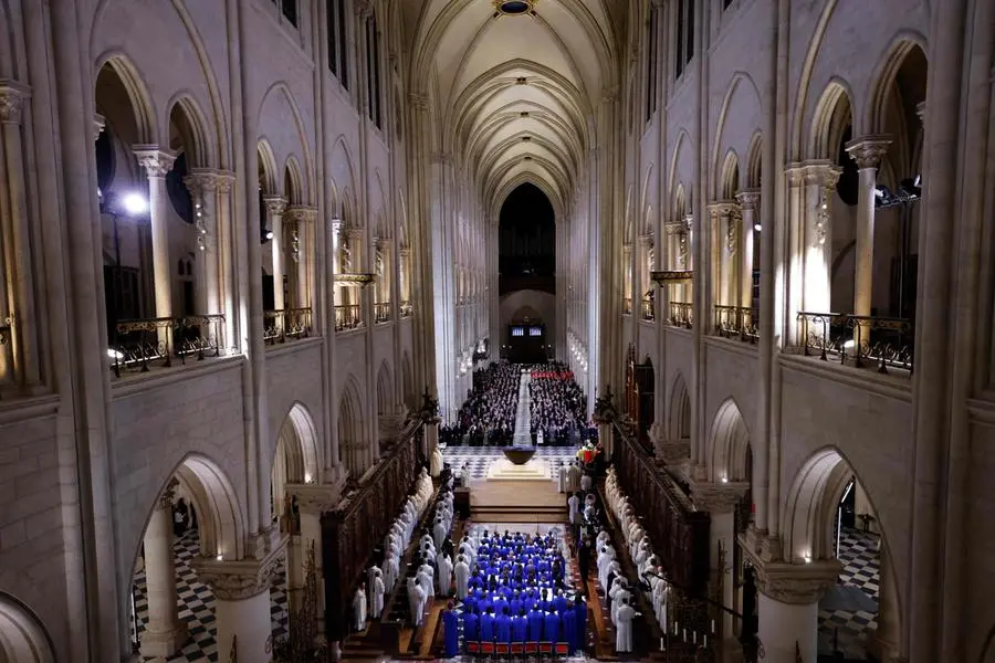 TOPSHOT - The choir, Clergy and guests stand as they sing during a ceremony to mark the re-opening of the landmark Notre-Dame Cathedral, in central Paris, on December 7, 2024. Around 50 heads of state and government are expected in the French capital to attend the ceremony marking the rebuilding of the Gothic masterpiece five years after the 2019 fire which ravaged the world heritage landmark and toppled its spire. Some 250 companies and hundreds of experts were part of the five-year restoration project at a cost of hundreds of millions of euros. (Photo by Ludovic MARIN / POOL / AFP)