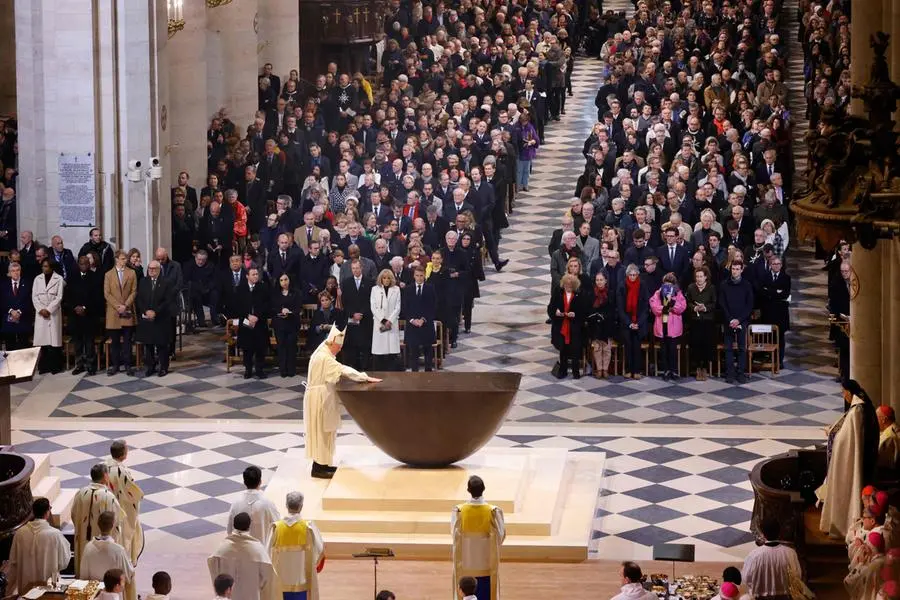 TOPSHOT - The Archbishop of Paris Laurent Ulrich (Centre-L) anoints the new main altar designed by French artist and designer Guillaume Bardet during its consecration as part of the first mass for the public, at the Notre-Dame de Paris cathedral, in Paris, on December 8, 2024. Newly restored Notre Dame cathedral is set to hold its first service for the public on December 8, 2024 after a historic re-opening ceremony that saw firefighters, builders and artists celebrated for their work saving the 12th-century masterpiece. The beloved Paris monument nearly burned down in 2019, but has been renovated inside and fitted with a new roof and spire during a frenzied reconstruction effort since then. (Photo by Ludovic MARIN / AFP) / RESTRICTED TO EDITORIAL USE - MANDATORY MENTION OF THE ARTIST UPON PUBLICATION - TO ILLUSTRATE THE EVENT AS SPECIFIED IN THE CAPTION