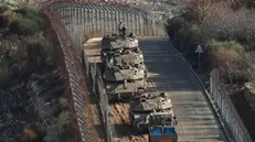 epa11764586 Israeli tanks deploy next to the security fence near the Druze village of Majdal Shams on Israel border with Syria in the Israeli-annexed Golan Heights, 08 December 2024. The Israeli army announced it has deployed forces to strengthen the defense of the Golan Heights and the eastern Israeli-border with Syria. Syrian rebels entered Damascus on 08 December 2024 and announced in a televised statement the 'Liberation of the city of Damascus and the overthrow of Bashar al-Assad', as well as the release of all the prisoners EPA/ATEF SAFADI