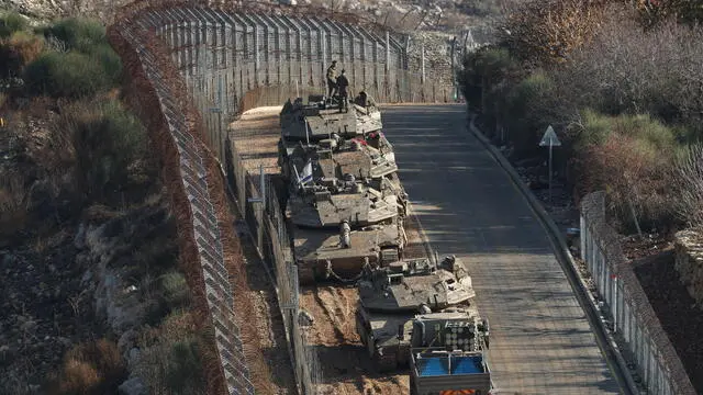 epa11764586 Israeli tanks deploy next to the security fence near the Druze village of Majdal Shams on Israel border with Syria in the Israeli-annexed Golan Heights, 08 December 2024. The Israeli army announced it has deployed forces to strengthen the defense of the Golan Heights and the eastern Israeli-border with Syria. Syrian rebels entered Damascus on 08 December 2024 and announced in a televised statement the 'Liberation of the city of Damascus and the overthrow of Bashar al-Assad', as well as the release of all the prisoners EPA/ATEF SAFADI