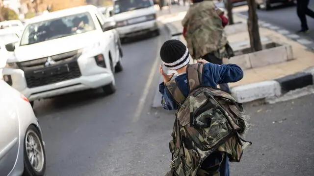 epa11766900 A child walks while wearing a military vest, one day after the overthrow of Syrian president al-Assad, in Damascus, Syria, 09 December 2024. Syrian rebels entered Damascus on 08 December 2024 and announced in a televised statement the 'Liberation of the city of Damascus and the overthrow of Bashar al-Assad', as well as the release of all the prisoners. EPA/HASAN BELAL