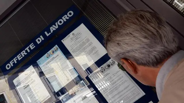 Un uomo controlla gli annunci di lavoro esposti in una agenzia per l'occupazione a Pisa. ANSA/FRANCO SILVI