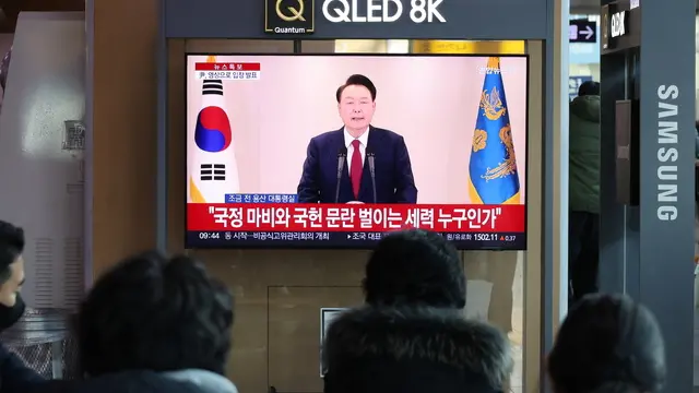 epa11771688 People watch live coverage of South Korean President Yoon Suk Yeol's public statement at Seoul Station in Seoul, South Korea, 12 December 2024. EPA/YONHAP SOUTH KOREA OUT