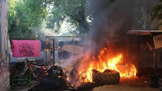 Un momento dei tafferugli durante lo sgombero da parte delle forze di polizia dell'ex caserma Masini occupata abusivamente da fine 2012 dal collettivo Labas in centro a Bologna, 8 agosto 2017. Gli agenti hanno affrontato i ragazzi del centro sociale in assetto antisommossa e con blindati, chiudendo la strada di accesso. Gli scontri sono durati una decina di minuti poi la Polizia è riuscita a entrare nell'edificio. ANSA/ GIORGIO BENVENUTI