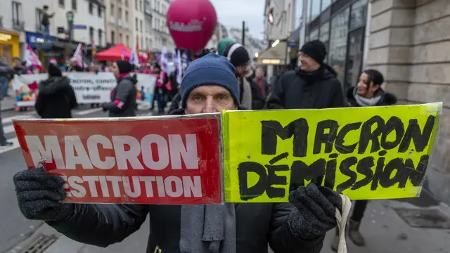 epa11772456 A protester holds a placard reading 'Macron Destitution, Macron resignation', during a demonstration led by the French Labor Union in defense of civil servants and the quality of public services in Paris, France, 12 December 2024. French civil servants are on strike across France on 12 December to demand more resources for the public sector and denounce the deterioration of their working conditions and remuneration. EPA/CHRISTOPHE PETIT TESSON