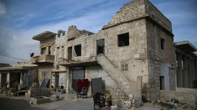 epa11773076 Children stand outside a damaged house in the Maarat al-Numan District near Idlib, northern Syria, 12 December 2024. Many locals left their houses in 2019, when thousands of homes across southern Idlib fell under the control of the Syrian regime. Locals say that, before withdrawing amid the advance of Syrian opposition forces, the regimeâ€™s militias stripped the metal roofing, looted furniture and valuables, and dismantled windows and doors, adding that even the electricity cables in the walls were pulled out. EPA/BILAL AL HAMMOUD