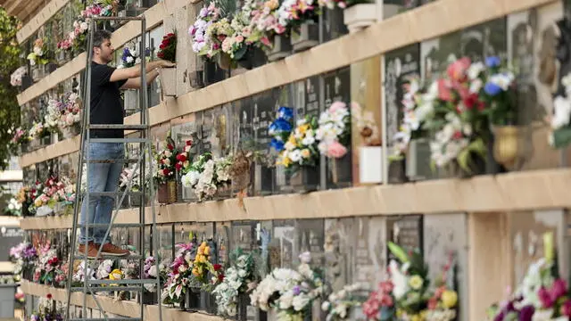 epa10274948 A man cleans a niche grave at Cementerio General cemetery during preparations for All Saint's Day in Valencia, eastern Spain, 30 October 2022. All Saints' Day is marked on 01 November. In Spain, people traditionally visit cemeteries to commemorate the holiday. EPA/BIEL ALINO