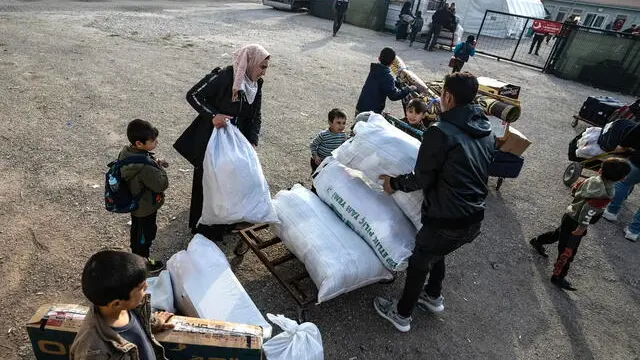 epaselect epa11772607 Syrians attend to their belongings while waiting to cross into Syria from Turkey at the Oncupinar border gate, near the town of Kilis, southern Turkey, 12 December 2024. The Political Affairs Department of the Syrian Salvation government called for all refugees outside Syria to return following the ousting of Syrian President Bashar al-Assad on 08 December, as the UN Refugee Agency (UNHCR) estimates that since 2011, more than 14 million Syrians were forced to flee their homes in search of safety. EPA/KAZIM KIZIL