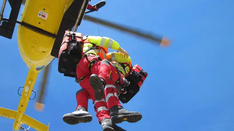 Un momento di un soccorso in aria con l’operatore che manovra il verricello per calare un tecnico