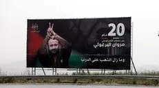 epa09895985 A picture on a billboard of Palestinian Fatah leader, Marwan Barghouti, near the West Bank city of Nablus, 18 April 2022. Barghouti began his 20th year in Israeli Jails after being arrested on 15 April 2002, and in 2004 was sentenced by an Israeli court to five life terms plus 40 years in prison. EPA/ALAA BADARNEH