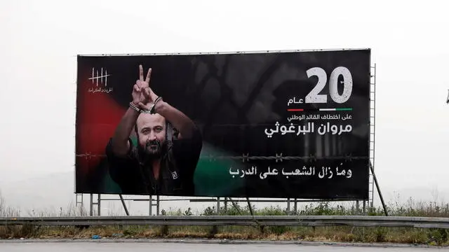 epa09895985 A picture on a billboard of Palestinian Fatah leader, Marwan Barghouti, near the West Bank city of Nablus, 18 April 2022. Barghouti began his 20th year in Israeli Jails after being arrested on 15 April 2002, and in 2004 was sentenced by an Israeli court to five life terms plus 40 years in prison. EPA/ALAA BADARNEH