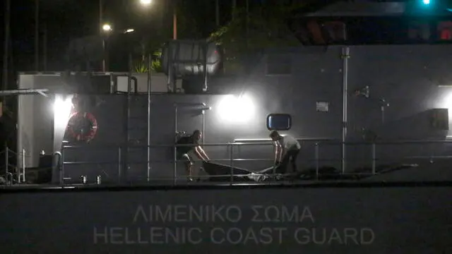 epa10691388 Greek coast guard personal carry the dead bodies of refugees and migrants from a coast guard ship following a deadly shipwreck off Pylos at the port of Kalamata, southwest of Athens, Greece, 15 June 2023. A total of 104 individuals were rescued, while 79 bodies were recovered, after a fishing boat capsized in international waters 47 nautical miles southwest of the Peloponnese coast and the town of Pylos. EPA/YANNIS KOLESIDIS