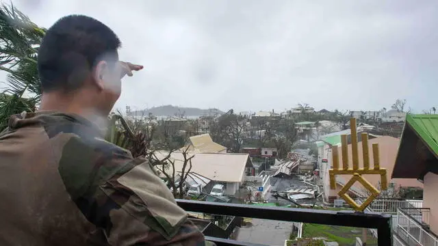 epa11778702 A handout photo made available by the French Army on 15 December 2024 shows a soldier at at an area overlooking damages in the French overseas territory of Mayotte. At least 14 people were killed and more than 200 injured after tropical cyclone Chido battered the French Indian Ocean territory of Mayotte on 14 December, authorities said. EPA/ETAT-MAJOR DES ARMEE HANDOUT -- BEST QUALITY AVAILABLE -- MANDATORY CREDIT: ETAT-MAJOR DES ARMEE -- HANDOUT EDITORIAL USE ONLY/NO SALES