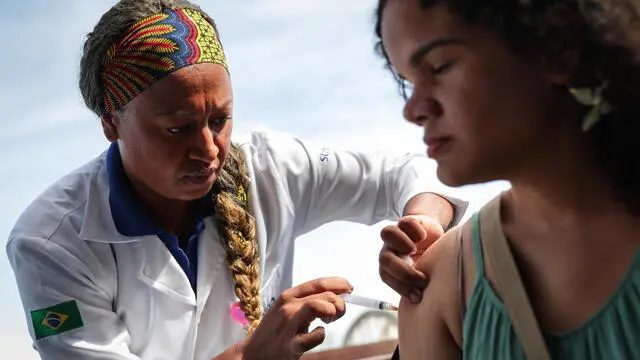 epa11158117 A woman receives a dose of the dengue vaccine during the start of vaccination in the Barra de Guaratiba neighborhood, in Rio de Janeiro, Brazil, 16 February 2024. The Government of Brazil began the vaccination of 20,000 inhabitants of a neighborhood in the city of Rio de Janeiro to evaluate the effectiveness of the vaccine against dengue in the adult population, amid a surge in cases across the country. EPA/ANDRE COELHO