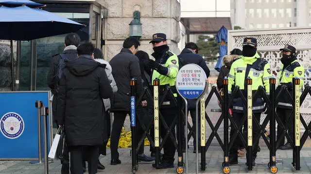 epa11773856 Policemen check ID cards at a gate of the National Assembly during a two-day restriction on public entry to the Assembly ahead of the second vote on a bill to impeach South Korean President Yoon Suk Yeol in Seoul, South Korea, 13 December 2024. EPA/YONHAP SOUTH KOREA OUT