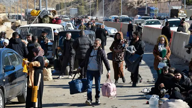 epa11777002 Syrians who have fled their country, including Shiite Muslims, walk with their belongings after they arrived from Syria, at the Al-Masnaa crossing as they prepare to enter Lebanon, on the Lebanese-Syrian border, Lebanon, 14 December 2024. Scores of Syrians who fled their country following the ousting of Syrian President Bashar al-Assad on 08 December, wait at the border crossing to enter Lebanon due to the unstable situation in their country. EPA/WAEL HAMZEH