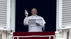 Papa Francesco mostra il Vangelo in formato tascabile che sarà distribuito ai fedeli durante la recita dell'Angelus in piazza San Pietro, Roma, 22 marzo 2015. Pope Francis shows a pocket edition of the Gospel during the Angelus Prayer in St.Peter's Place, Vatican City, 22 March 2015. ANSA / FABIO FRUSTACI