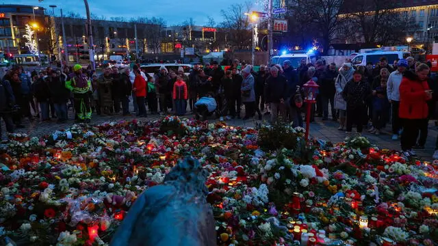 epa11788641 People gather at the official mourning site in front of St. John's Church to pay their respects following a vehicle-ramming attack on the Christmas market, in Magdeburg, Germany, 21 December 2024. According to Saxony-Anhalt State Premier Reiner Haseloff, five people were confirmed dead and at least 200 were injured, after a car was driven into a crowd at Magdeburg's Christmas market on 20 December. The suspect, a Saudi national, was taken into custody. EPA/FILIP SINGER