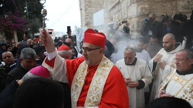 epa11042959 The Latin Patriarch of Jerusalem Pierbattista Pizzaballa arrives at the Manger Square to attend the midnight Christmas Mass at the Church of the Nativity, in the West Bank town of Bethlehem, 24 December 2023. Church leaders in the historical Christian town of Bethlehem, traditionally revered as the birthplace of Jesus, have announced the cancelation of public Christmas celebrations this year in solidarity with the people of Gaza amid the ongoing Israel-Gaza conflict. Christmas activities will be limited to worship and prayer, without the usual Christmas lights and tree. EPA/Wisam Hashlamoun